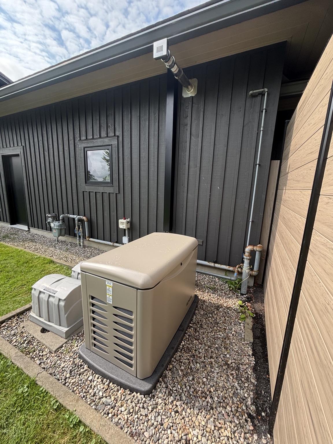Standby generator installed beside a modern home